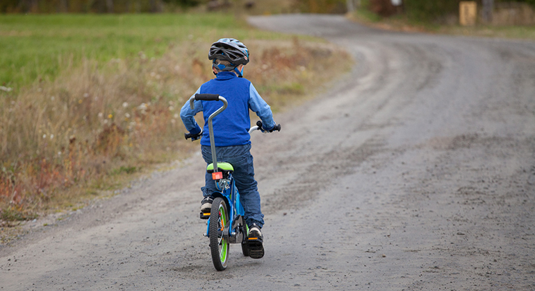 Barn cyklar på grusväg. Foto: Martin Fransson.