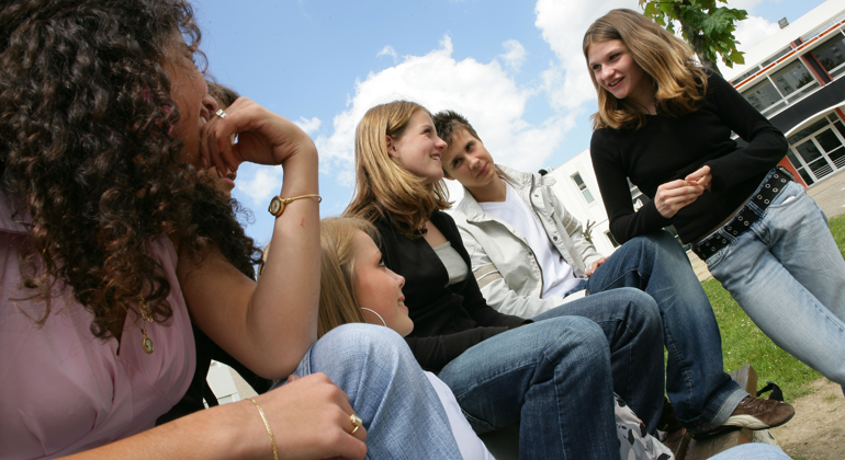 En grupp tonåringar på en skolgård.